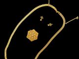un ensemble composé d'un collier et de boucles d'oreilles en or sur fond noir