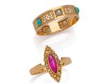 two gold rings and a pink stone ring on a white background