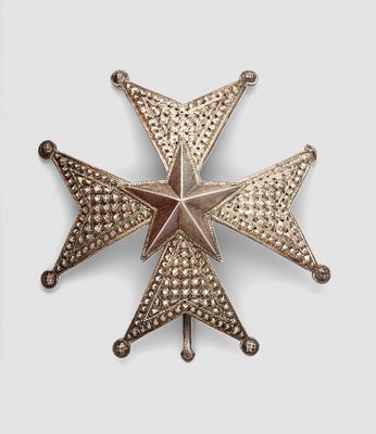 an antique silver and gold star broochle on a white background