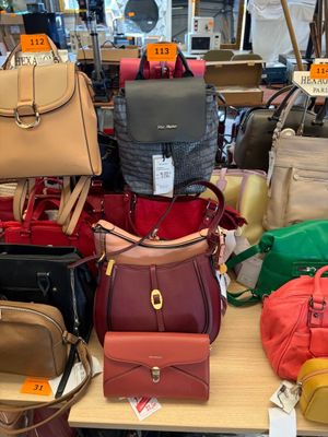 a lot of purses on a table in a store