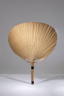 un éventail en bois posé sur une surface blanche