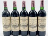 quatre bouteilles de vin sont alignées sur une surface blanche