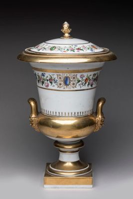 une image représentant un vase blanc et doré muni d'un couvercle