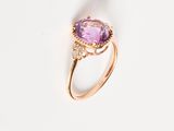 a close up of a ring with a purple stone and diamonds