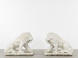 une paire de lions en marbre blanc sur des socles en marbre