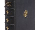 un livre noir orné de bordures dorées et d'un emblème doré