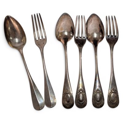 six spoons and a fork are lined up on a white surface