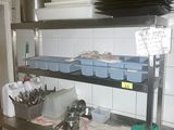 une étagère métallique avec des casseroles et des poêles dans une cuisine