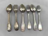 six spoons and a fork are lined up on a table
