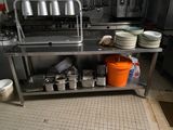 une cuisine avec de nombreux plats posés sur le plan de travail et une casserole sur l'étagère