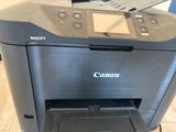 a canon printer sitting on top of a wooden floor next to a computer