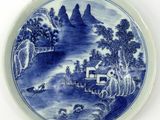 a blue and white plate with a painting on it