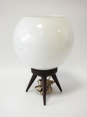 a white ball on a wooden stand with a rope around it