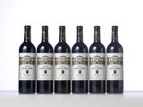 four bottles of wine are lined up on a table