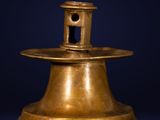 an antique brass bell on a dark blue background