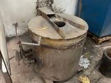une photo d'une cuisine sale avec une grande casserole posée par terre