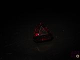 un diamant rouge posé sur une surface noire