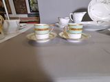 two cups and saucers sitting on a table