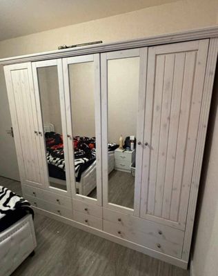 a bedroom with a closet and a bed with a zebra print blanket on it