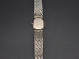 an image of a silver watch with a white face on a black surface