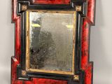 un cadre photo rouge et noir contenant un miroir