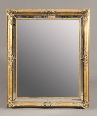 un miroir à cadre doré sur fond gris