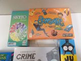 several board games are on a table with a box of cards
