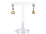 une paire de boucles d'oreilles en perles et diamants, présentée sur un présentoir