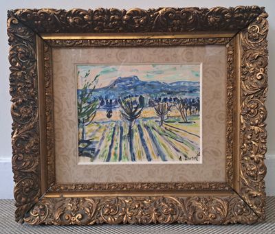 tableau représentant un paysage, dans un cadre doré, posé sur un tapis