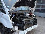 a white van with a broken hood in a parking lot