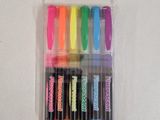 six different colored markers in a plastic case