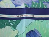 a close up of a blue and green scarf with flowers on it