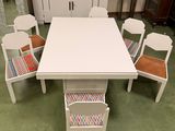 une table blanche entourée de six chaises dans une pièce