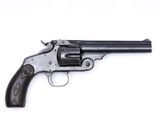 un vieux revolver avec un manche en bois sur fond blanc