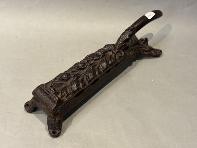un vieux support de tuyau en fonte posé sur une surface blanche