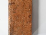 an old book sitting on a white surface with a white background