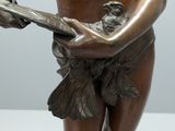 bronze statue of a boy holding a book and a bird