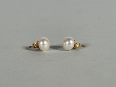 a pair of pearl earrings on a white surface