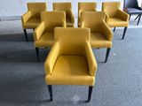 six chaises jaunes aux pieds noirs dans une pièce aux murs blancs