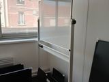 a white refrigerator in the corner of a room next to a window