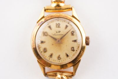 une image d'un gros plan d'une montre-bracelet sur une surface blanche