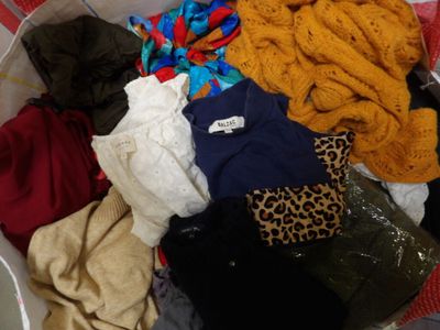 a basket full of clothes that is sitting on the floor