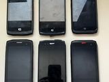 six cell phones are lined up in a row on a table