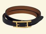 Gros plan sur une ceinture noire avec une boucle dorée
