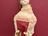 a doll that is sitting on top of a stand