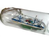 a boat in a bottle on a white surface