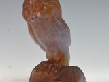 a statue of an owl that is sitting on top of a rock