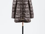 un manteau à col de fourrure posé sur un présentoir pour mannequin