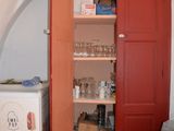 a red door that is open to reveal a pantry
