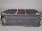 a black suitcase sitting on a table with a brown handle